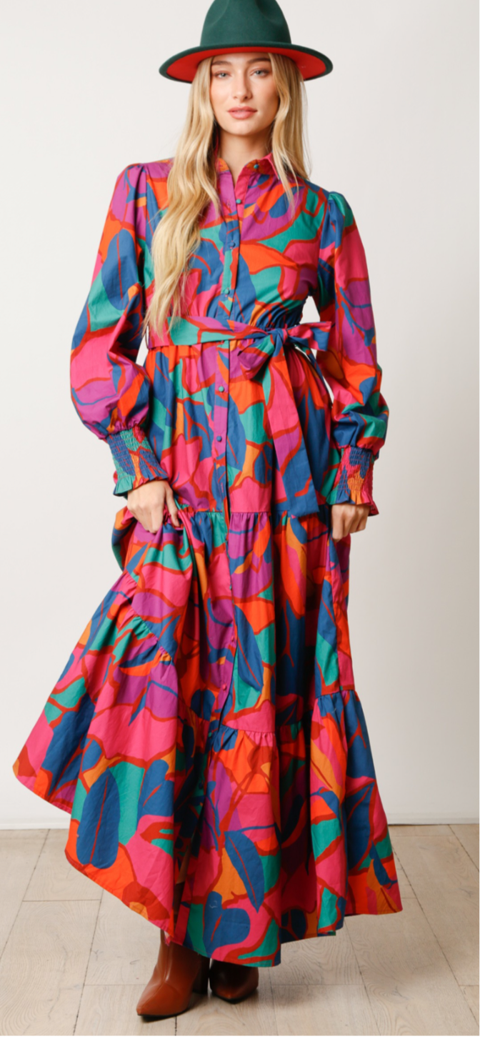 Woman wearing a colorful patterned dress with a plain background